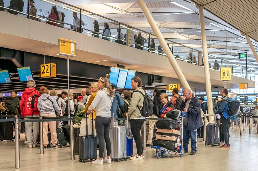 Reizigers checken in op Schiphol
